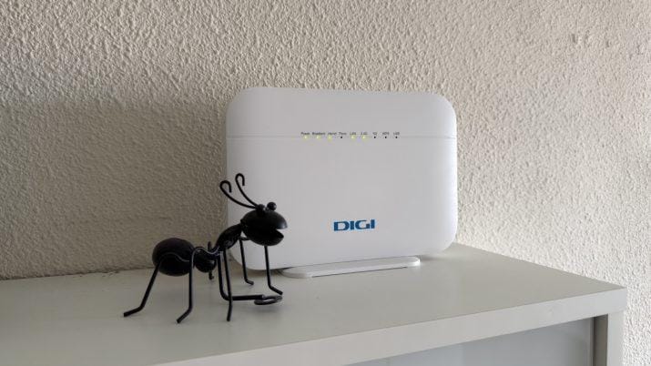 Router Wi-Fi moderno sobre una superficie de madera mostrando sus luces LED de estado encendidas en color verde y azul