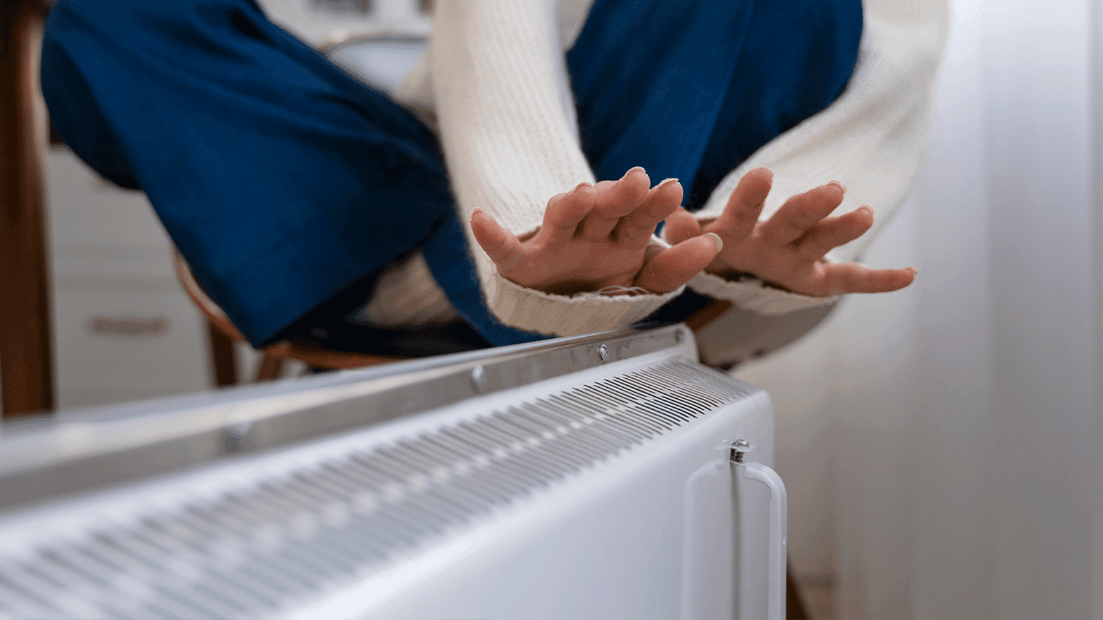 Radiador de calefacción de gas moderno instalado en una pared de color claro, mostrando el termostato para regular la temperatura y ahorrar energía