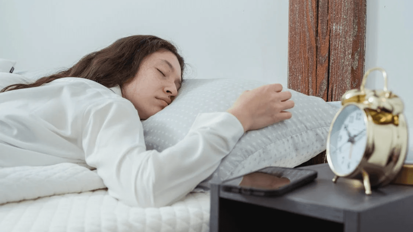 mujer durmiendo con móvil en la cama