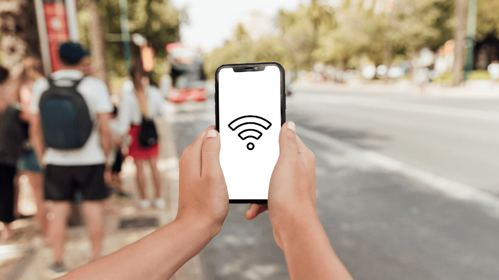 Un hombre intentando mejorar la señal de su smartphone a las afueras