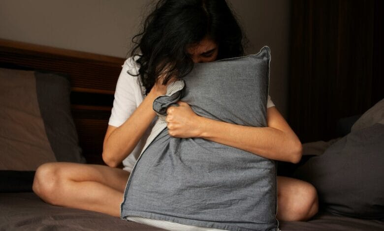 Imagen de una persona acostada en la cama con los ojos abiertos, simbolizando el insomnio