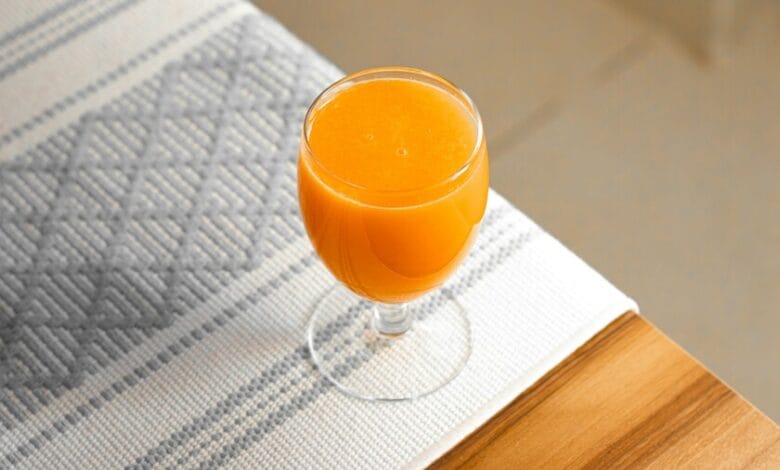 Imagen de una naranja y un vaso de zumo, con un círculo rojo de prohibición sobre el zumo