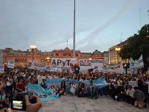 Persona con discapacidad en una silla de ruedas, con un fondo de personas protestando