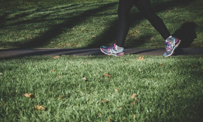 Persona caminando en un parque con un smartwatch en la muñeca