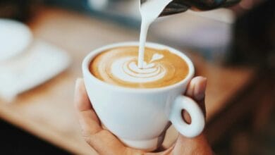 Una taza de café humeante sobre una mesa de madera