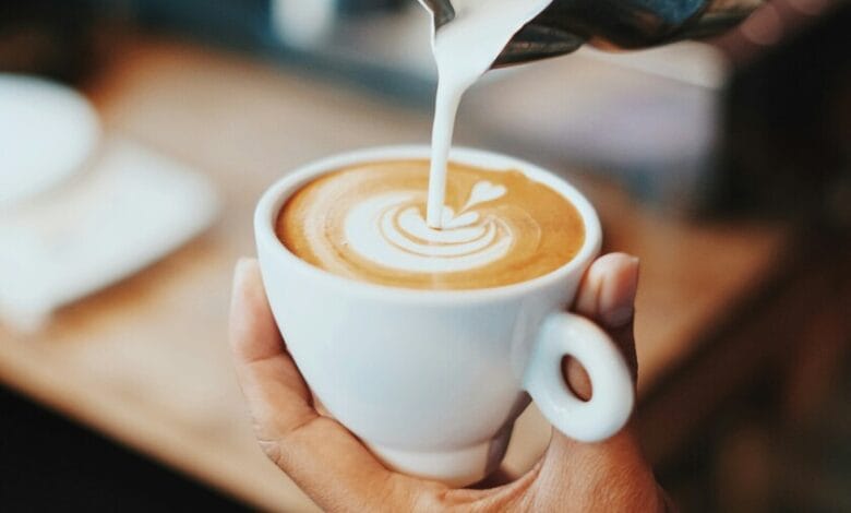 Una taza de café humeante sobre una mesa de madera