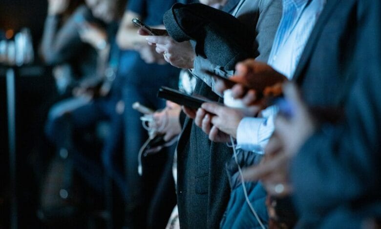 Persona mirando su teléfono con expresión de ansiedad