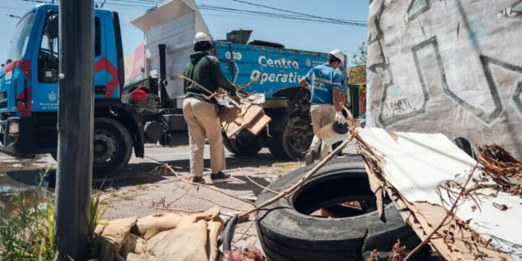 Personal municipal recoge elementos que puedan acumular agua en un barrio