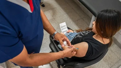 Una madre embarazada sonriente con un bebé en brazos