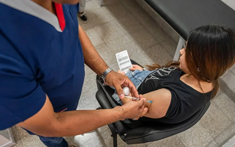 Una madre embarazada sonriente con un bebé en brazos