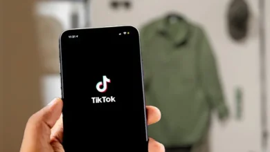 Imagen de la aplicación TikTok en un dispositivo móvil con un fondo de código de programación