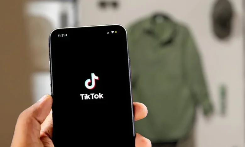 Imagen de la aplicación TikTok en un dispositivo móvil con un fondo de código de programación