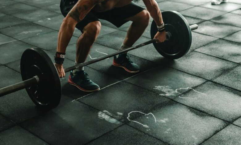 Persona mayor realizando sentadillas con ayuda de un profesional de la salud