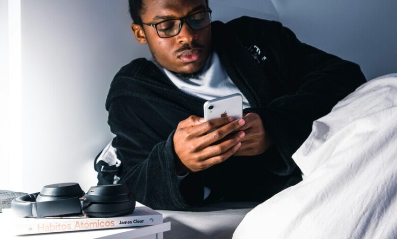 Persona durmiendo con su móvil en la mesilla de noche