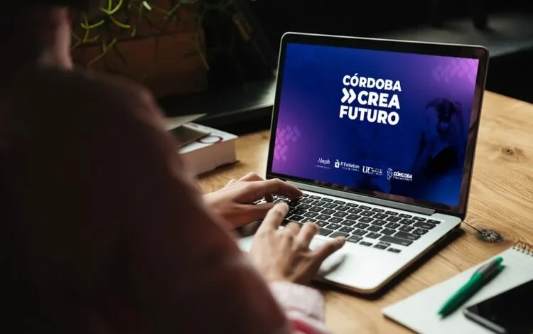 Imagen de una persona trabajando en una computadora con una pantalla que muestra código