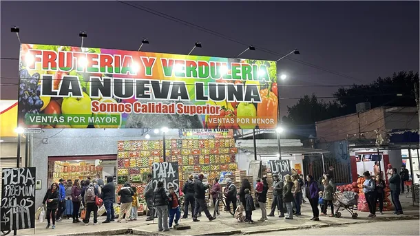 Imagen de la fachada de la verdulería "La Nueva Luna" con clientes comprando