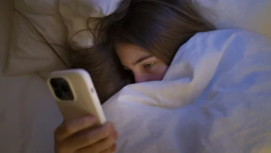 Una persona mirando un móvil en un espacio oscuro