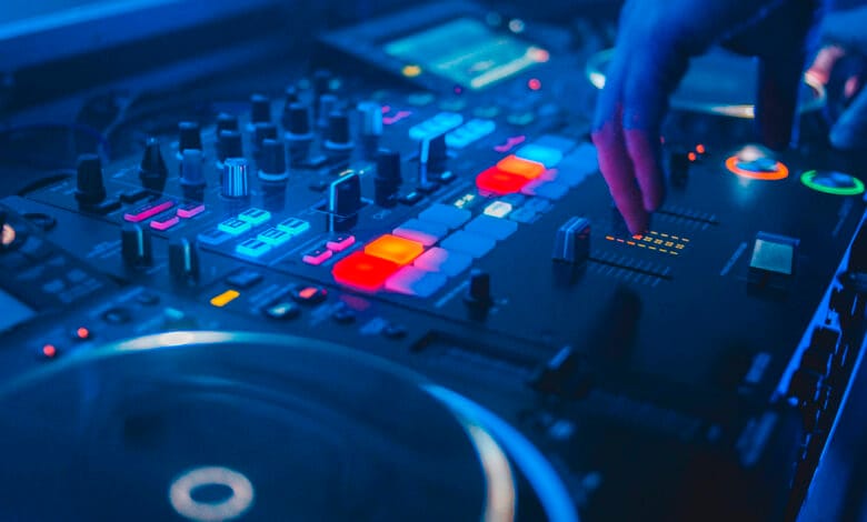 Imagen de un DJ en acción con un fondo de gente bailando