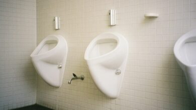 Hombre sentado en un baño, orinando