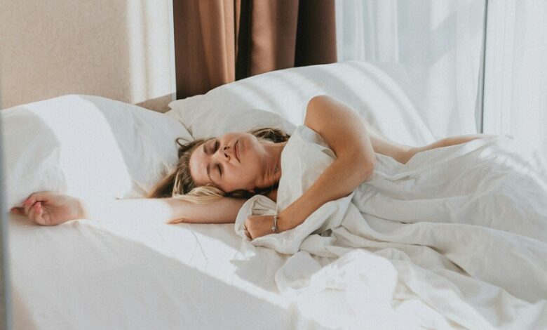 Imagen de una persona durmiendo en una cama con una luz suave en el fondo