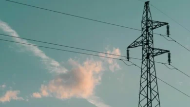 Imagen de un poste de electricidad con un trabajador realizando mantenimiento