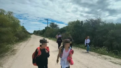 Niños caminando por un camino de tierra en Villa Posse