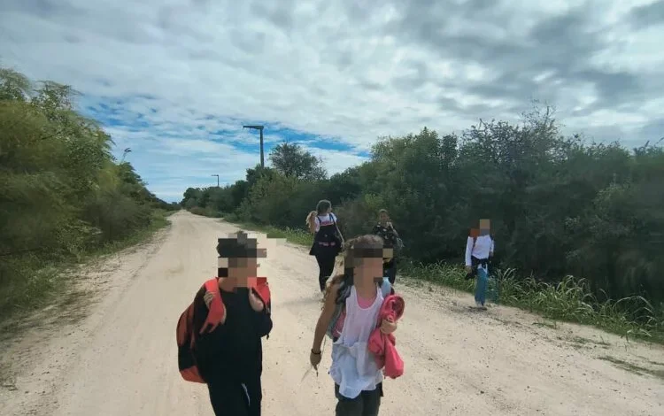 Niños caminando por un camino de tierra en Villa Posse