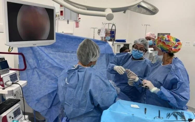 Equipo médico realizando cirugía digestiva por laparoscopía en recién nacido