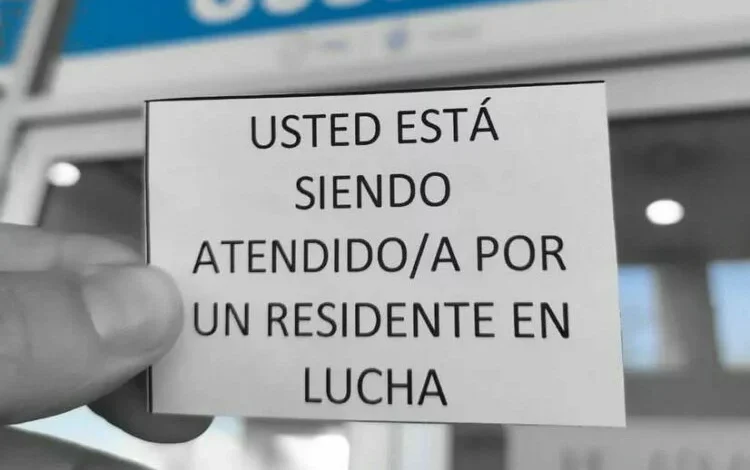 Médicos residentes con carteles en el exterior del hospital