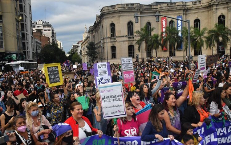 Mujeres marchando con carteles y banderas en una manifestación feminista