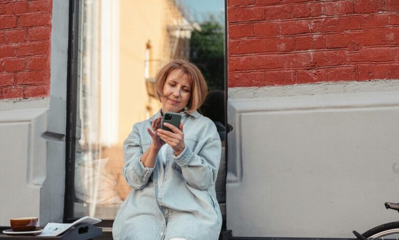 Mujer sonriente con una tableta, simbolizando el empoderamiento a través de la tecnología durante la menopausia
