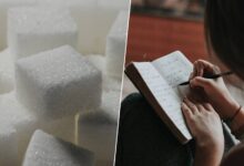 Una persona estudiando con un vaso de azúcar al lado