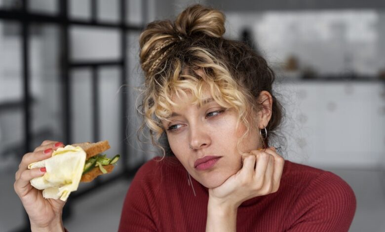 Una persona con cara de enfado y un plato de comida vacío