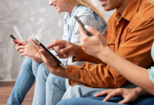 Persona sentada frente a una computadora, observando una pantalla con una expresión reflexiva