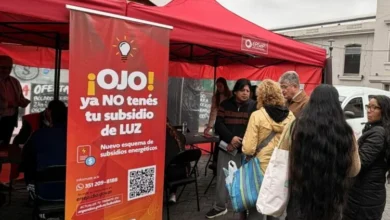 Persona con una factura de la luz en la mano, mirando hacia una computadora con la página web del ERSeP