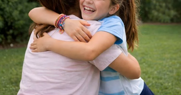 Niña sonriente con una pulsera que ella misma creó