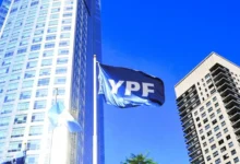 Imagen de un edificio de YPF con un fondo de banderas argentinas