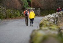 Dos personas caminando juntas en un paisaje natural