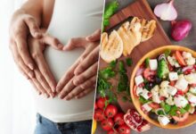 Imagen de una mujer embarazada con una sonrisa, rodeada de frutas y verduras frescas