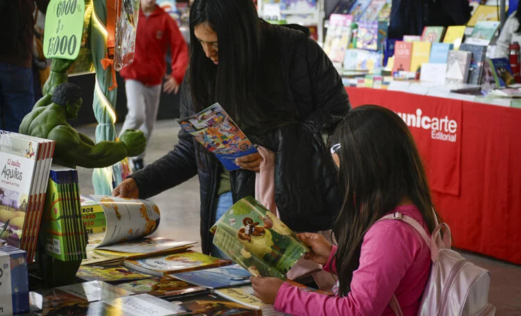 Niños leyendo libros de colores en una biblioteca