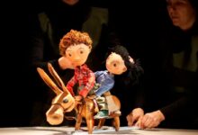 Imagen de una función de teatro al aire libre con público diverso