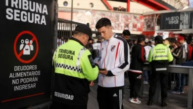 Imagen de un estadio de fútbol con una persona siendo detenida por seguridad