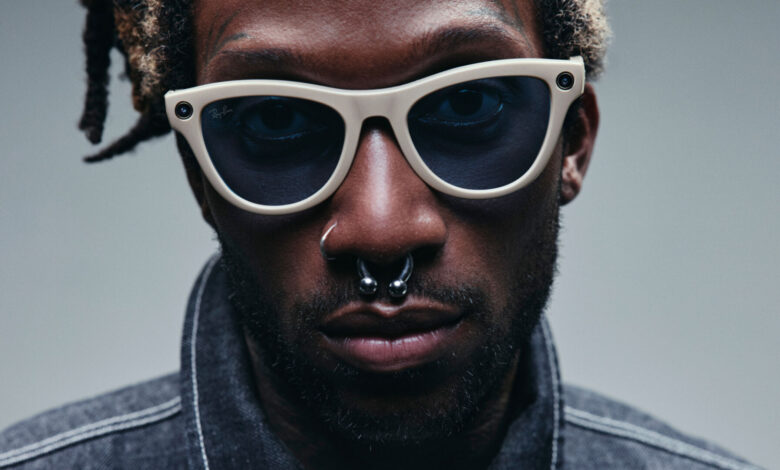 Gafas Ray-Ban Meta en una mano, con una pantalla de privacidad en el fondo