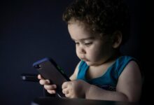 Un padre ignorando a su hijo para usar su móvil durante una comida