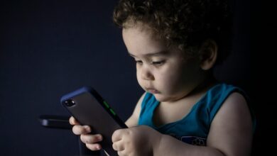 Un padre ignorando a su hijo para usar su móvil durante una comida