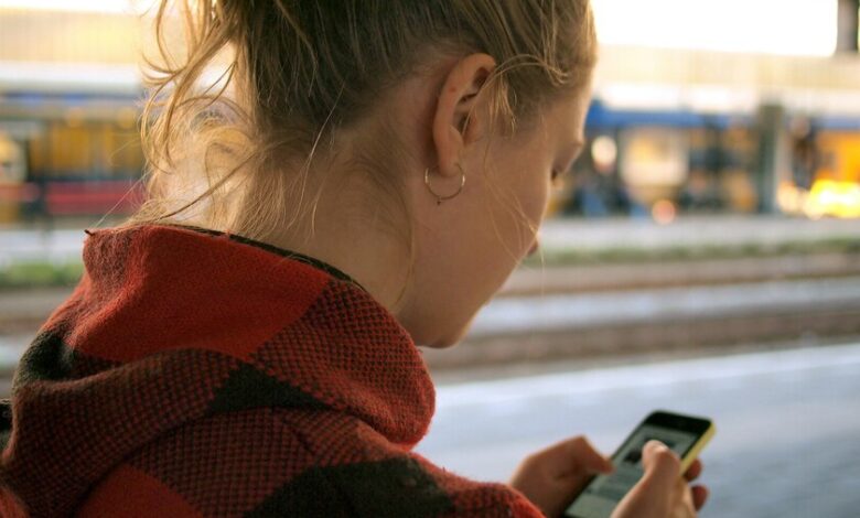 Una imagen de una persona joven interactuando con una pantalla que muestra una conversación con una IA