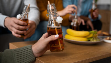Una botella de kombucha con una hoja de té