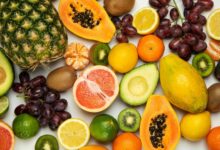 Variedad de frutas y verduras frescas sobre una mesa de madera
