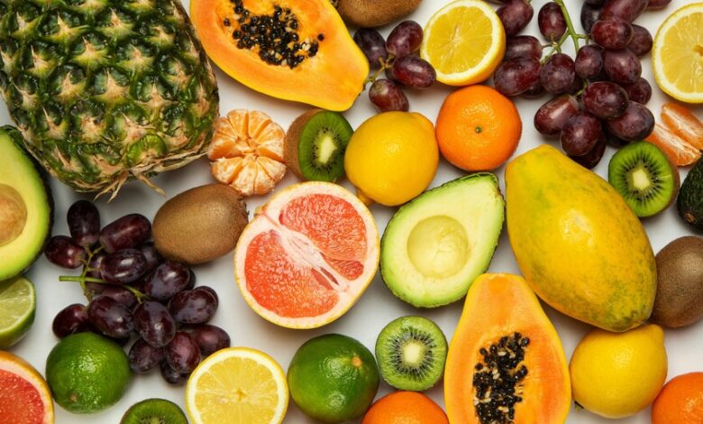 Variedad de frutas y verduras frescas sobre una mesa de madera