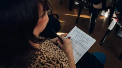 Personas en un aula de capacitación con profesores y materiales de estudio